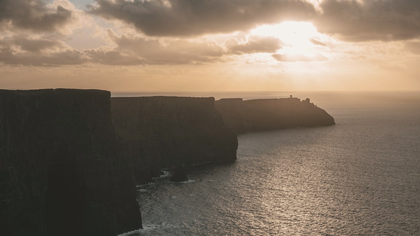 Sunset over dark sea cliffs on the Irish coast